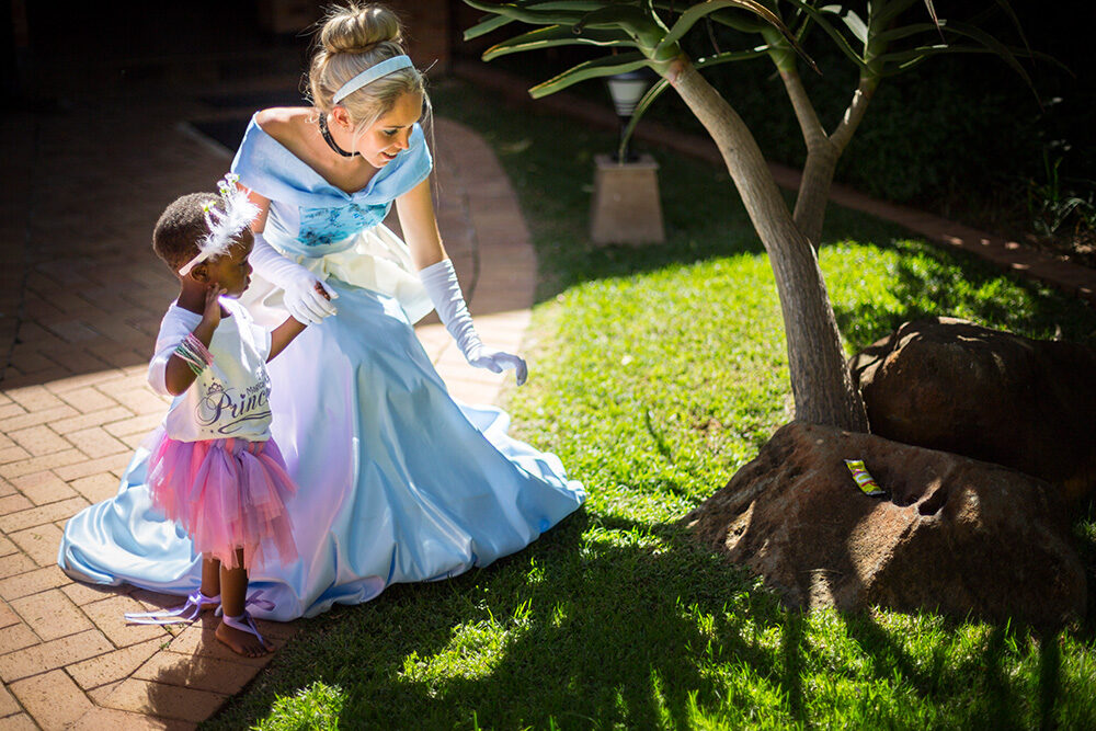 Children laughing and reaching for bubbles at a Magical Moments princess party